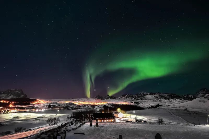 The northern lights over snow-covered mountains in Arctic Norway
