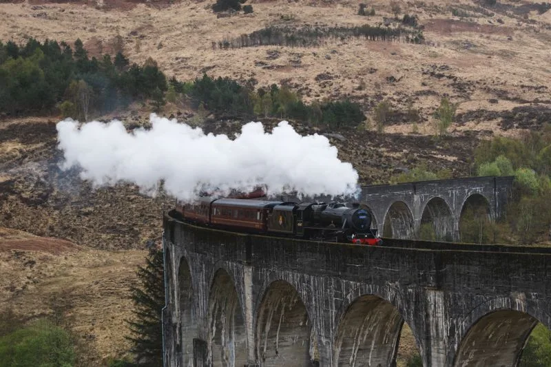 The Jacobite steam train crossing the Glenfinnan Viaduct in the Scottish Highlands
