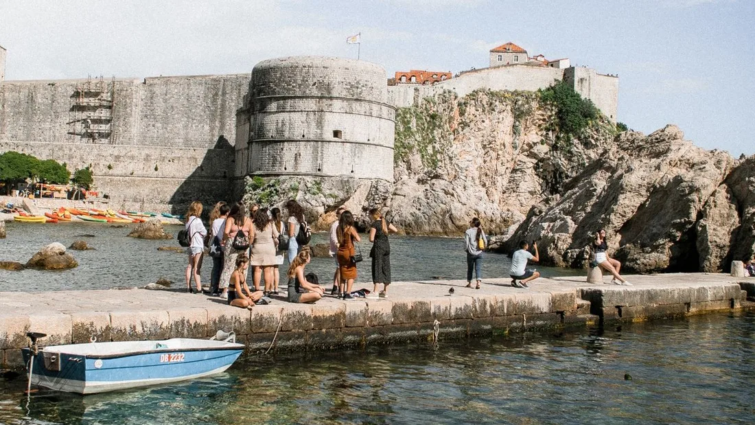 A group gathered on the quay below Dubrovnik's city walls