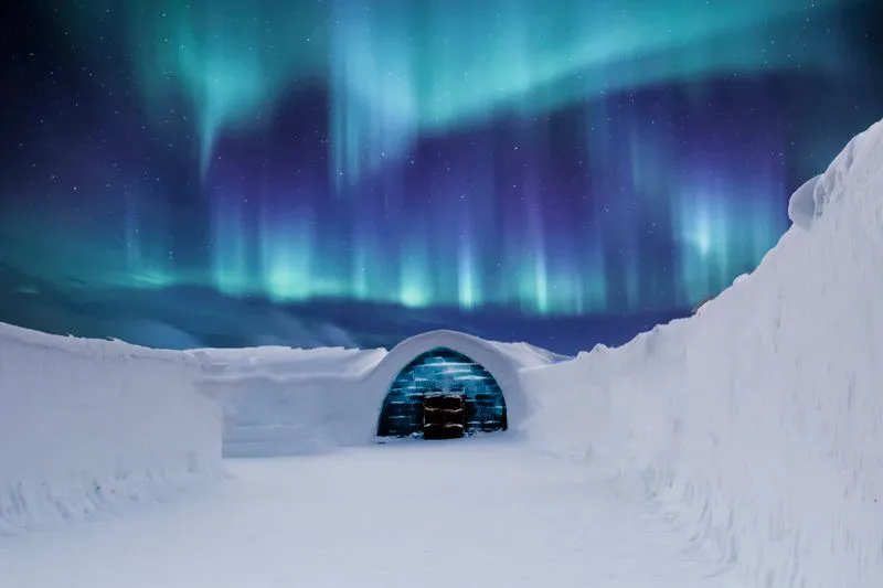The northern lights above a snow igloo in Finnish Lapland