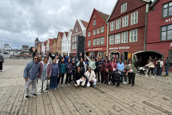 An HCG group in front of the wooden wharf houses at Bryggen, Bergen