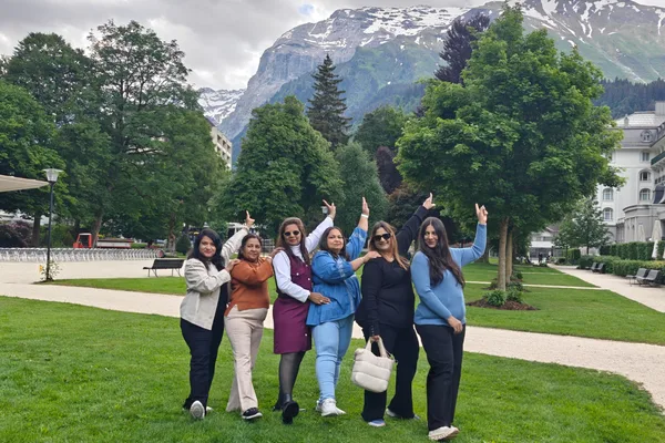 An HCG group in a park below snow-capped Alpine peaks