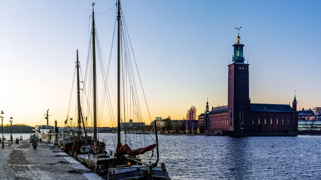 Sailing ships moored on the Stockholm waterfront below the City Hall